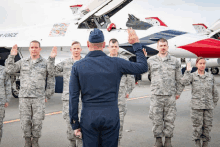 a group of soldiers are standing in front of a plane that says air force