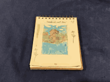 a notebook with a drawing of a house and the words " i love you " on the top right