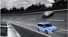 a ford van is driving down a highway next to a car