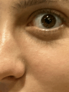 a close up of a woman 's eye with a very dark pupil