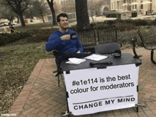 a man is sitting at a desk with a sign that says change my mind