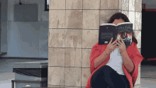 a woman sitting on the floor reading a book called mysteries of the classics