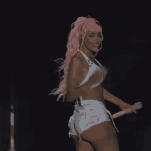 a woman with pink hair and white shorts is holding a pink microphone .