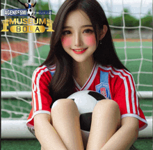 a girl in a red and white jersey holds a soccer ball in front of a museum bola sign