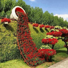 a sculpture of a bucket filled with red flowers and greenery