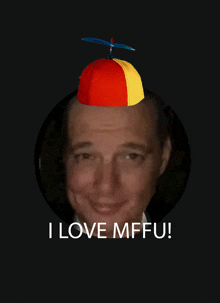 a man wearing a red and yellow hat with a propeller on it and the words i love mffu