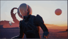 a man in a futuristic suit is standing in the desert with a light bulb in the foreground