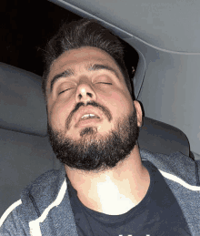 a man with a beard has his eyes closed