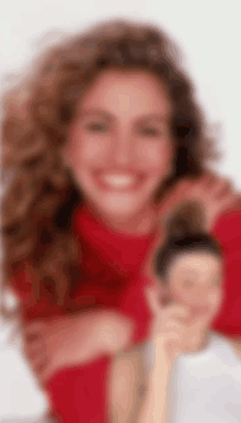 a woman in a red sweater is smiling and holding a small doll