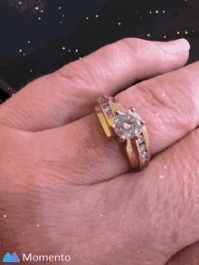 a close up of a woman 's hand with a ring on it that says momento on the bottom