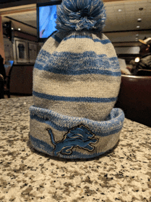 a blue and white striped beanie with a lion on it