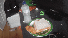 a plate with a sandwich and crackers on it next to a bottle of water