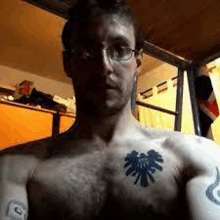 a shirtless man with a tattoo on his chest and arms .