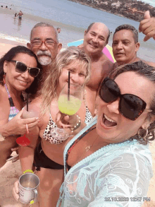 a group of people posing for a picture on a beach with the date 25.10 2020