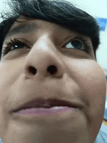 a close up of a person 's face with their mouth open and their eyes looking up .