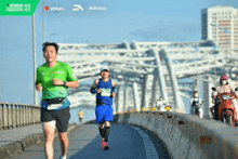 a man in a green shirt is running on a bridge sponsored by aia