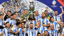 a group of soccer players celebrate with a trophy that says copa america on it