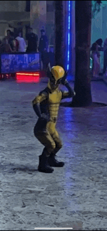 a person dressed in a wolverine costume is dancing on a sidewalk .