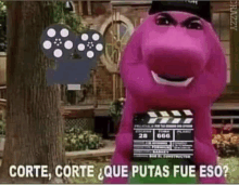 a purple cartoon character with a movie clapper board on his back .