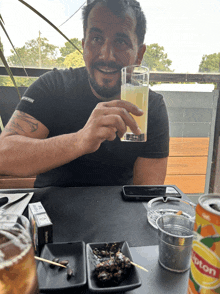 a man sits at a table with a can of lipton