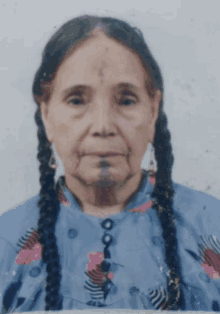 an older woman with braids and a tattoo on her face