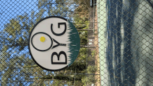 a sign on a chain link fence that says bg