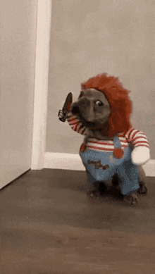 a dog dressed as chucky is holding a knife in its paw .