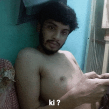 a shirtless man with a beard is laying on a bed with the question " ki " on the bottom