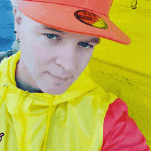 a man wearing a yellow and red jacket and an orange hat with the letters u.s.a. on it