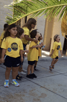 a group of children wearing yellow shirts that say aam park