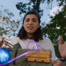 a woman is holding a power rangers toy in her hand .