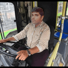 a man in a striped shirt is sitting in a bus