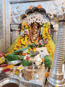 a temple with a statue of a deity surrounded by flowers