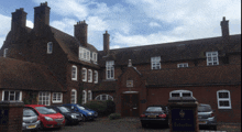 a row of cars are parked in front of a brick building