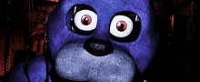 a purple stuffed animal with red eyes and a black nose