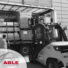 a forklift is loading a truck with able written on the bottom