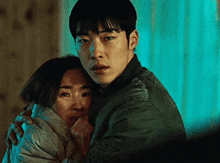 a man and a woman hugging each other in a dark room .