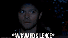 a close up of a man 's face with the words `` awkward silence '' written on the bottom .