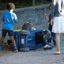 a boy in a blue shirt is standing next to a toy truck that has the number 10 on it