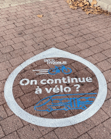 a circle painted on a brick sidewalk says on continue a velo