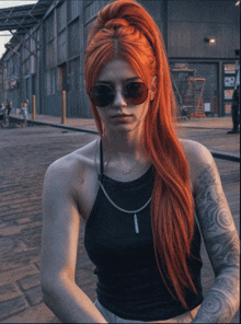 a woman with red hair wearing sunglasses and a black top