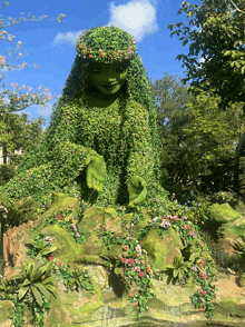 a statue of a woman made of green plants