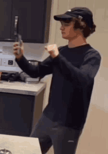 a man in a baseball cap is taking a picture of himself in a kitchen .