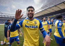 a man wearing a yellow and blue jersey with bet365 on the front