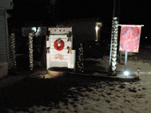 a christmas wreath hangs on a white door in the snow