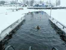 a person is swimming in a body of water in the winter