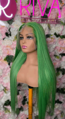 a green lace front wig is on a mannequin head