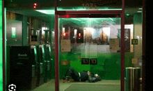 a man laying on the floor in front of a bank with the number 1031 on the door