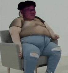 a very fat person is sitting in a chair with a purple face .