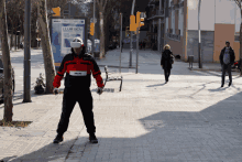 a man wearing a virtual reality headset stands on a sidewalk in front of a llum bcn sign